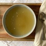 bowl of bone broth on wooden tray