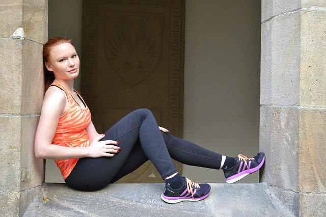 woman sitting with new workout leggings, top, and shoes 