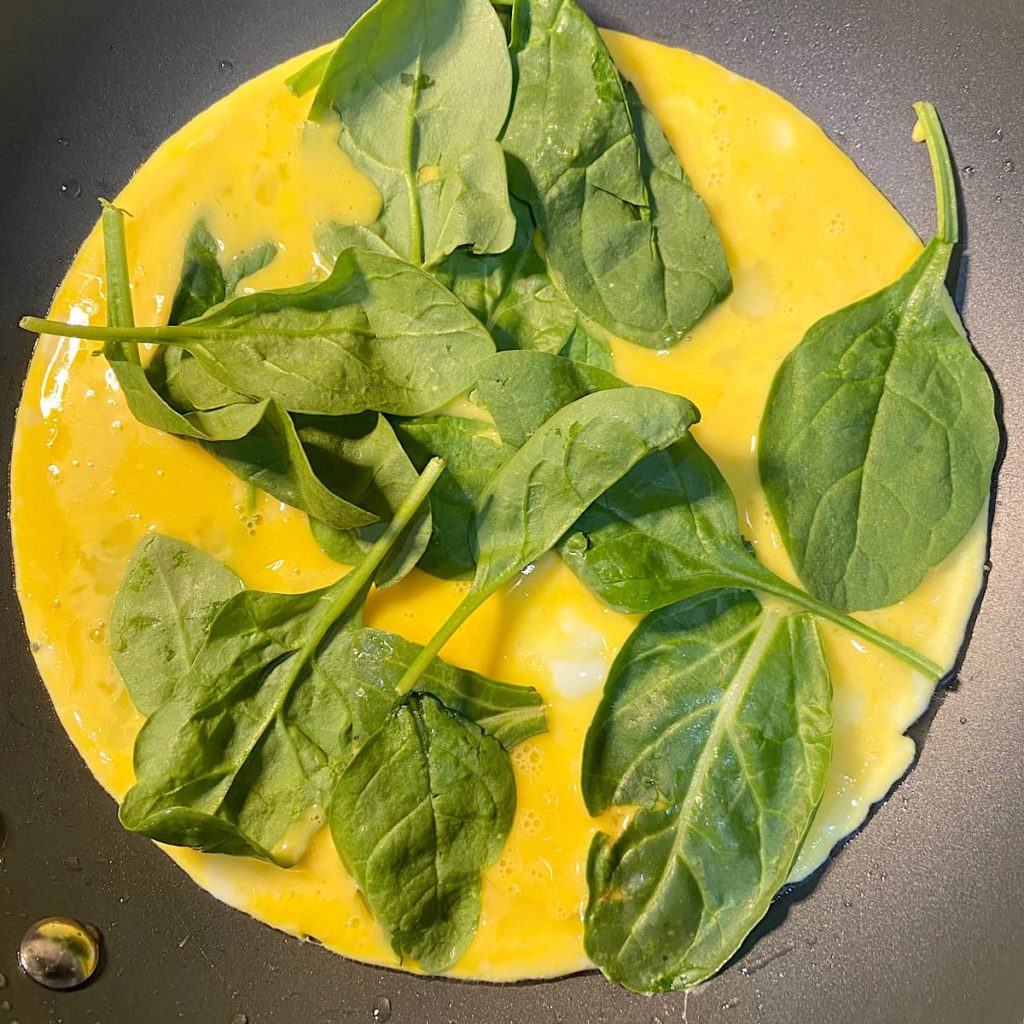 spinach and whisked eggs for vegetable omelet