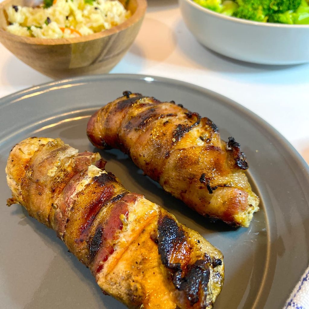 bacon wrapped grilled chicken breasts on a plate
