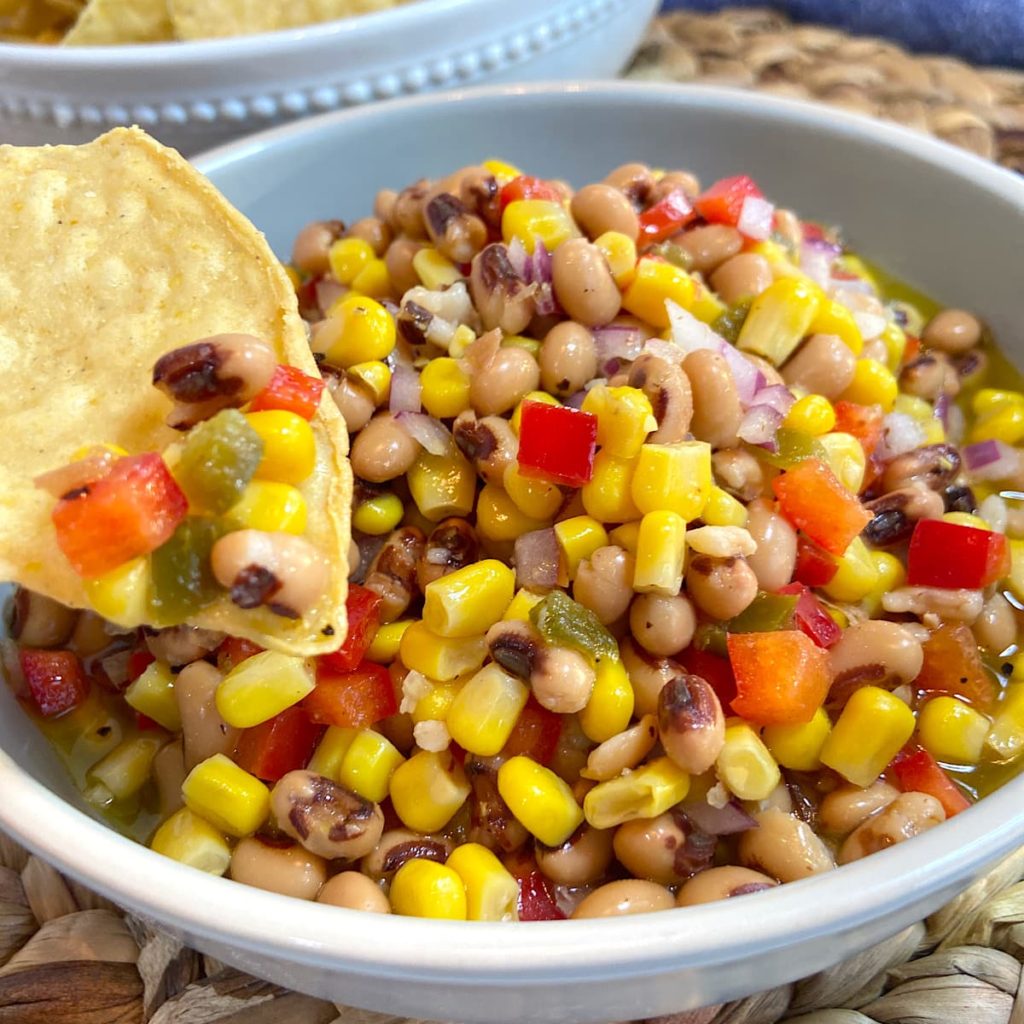 corn and black eyed pea dip with a chip