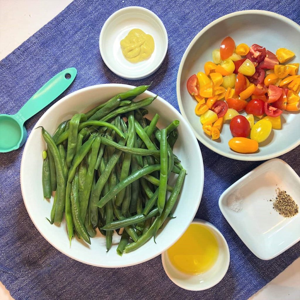 Spread of measured ingredients for green bean tomatoes with mustard vinaigrette