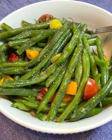 prepared green beans and tomatoes in bowl ready to serve
