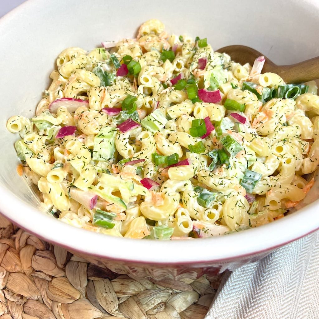creamy vegetable pasta salad in red bowl