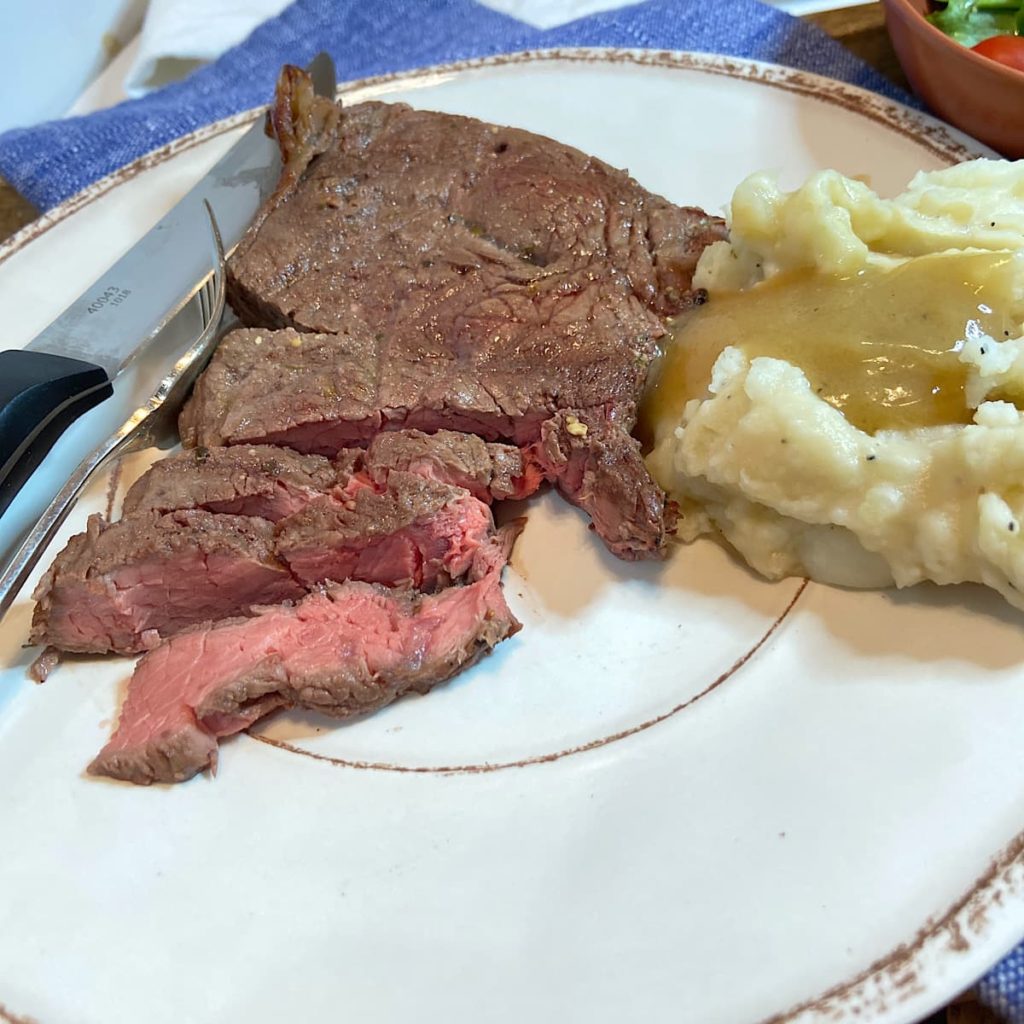 grilled steak on plate with mashed potatoes