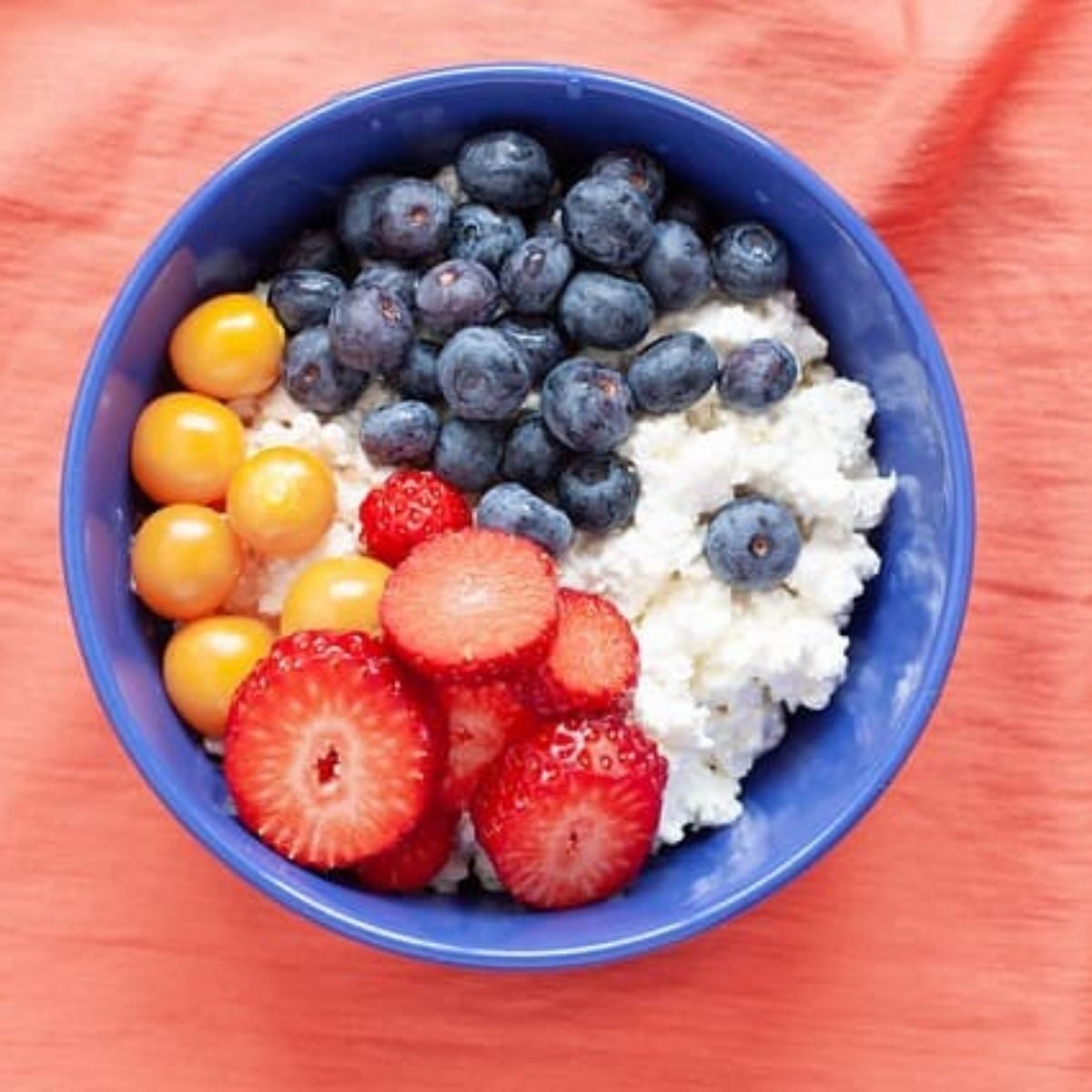 bowl of cottage cheese, blueberries, strawberries, grapes, and walnuts.