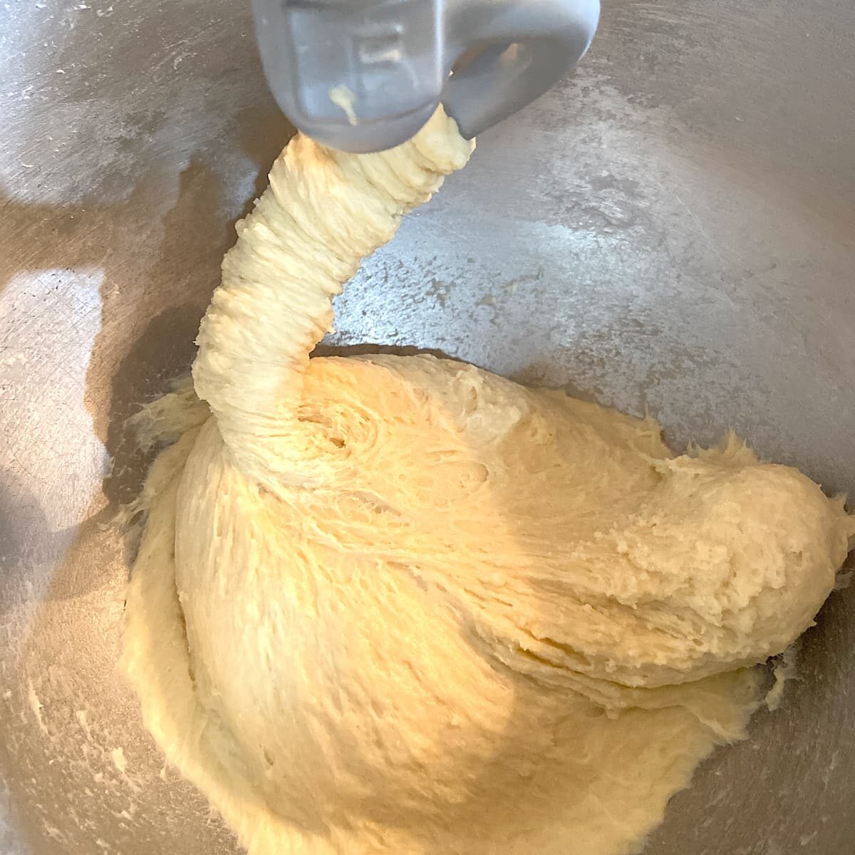 cinnamon roll dough climbing a dough hook.