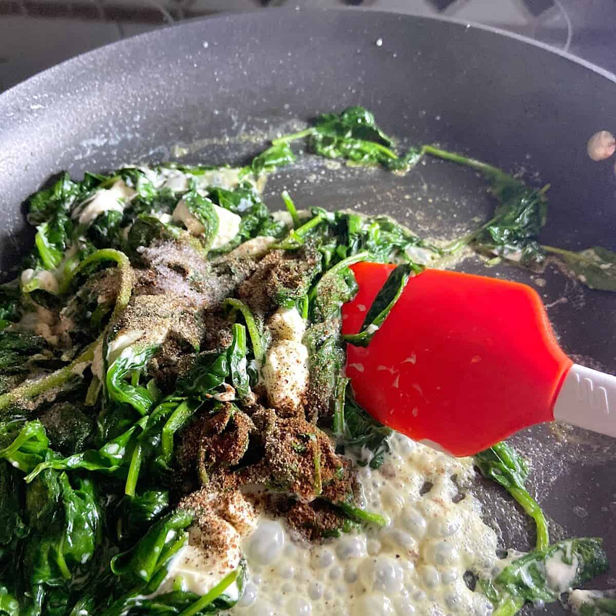 adding spices to spinach mixture