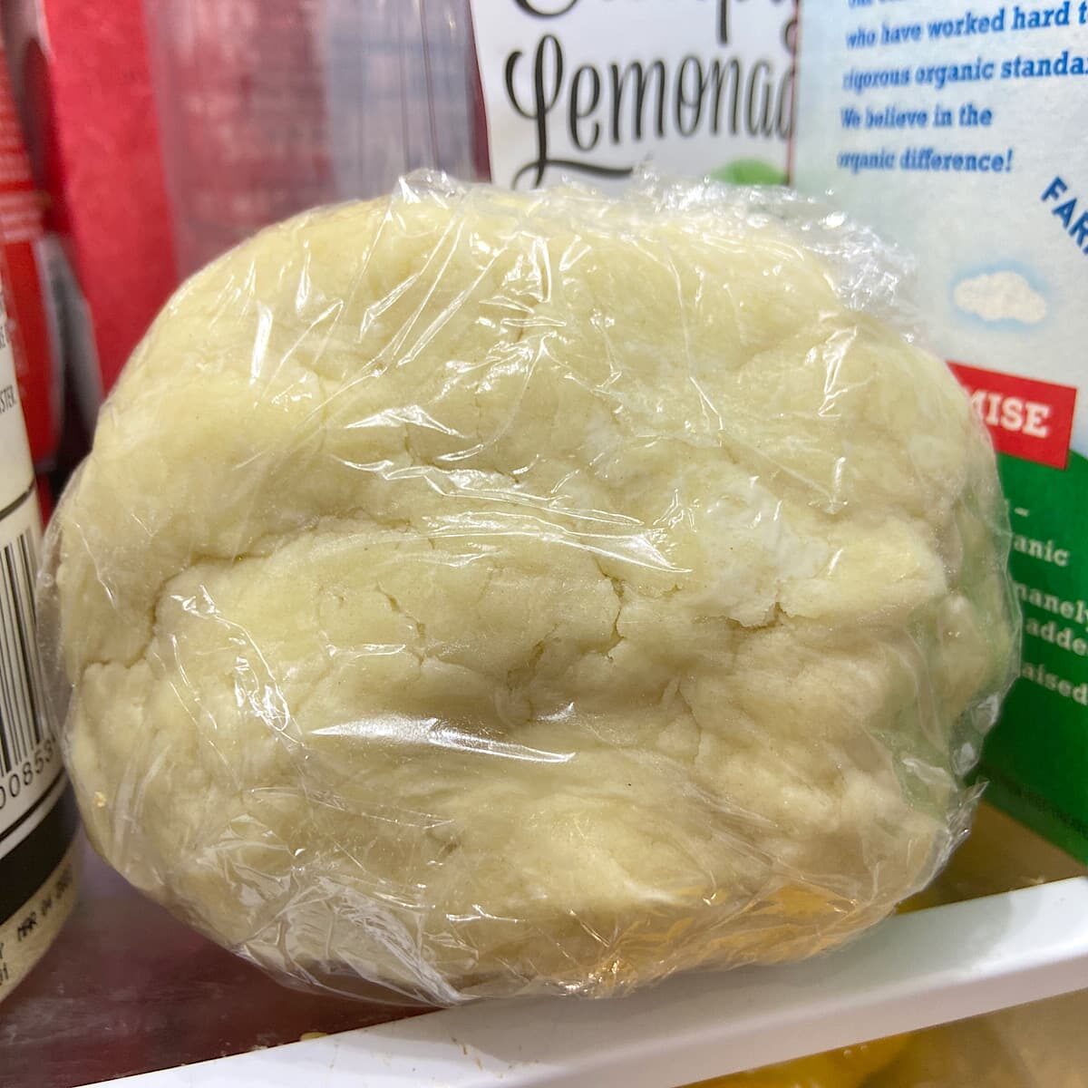 dough wrapped in plastic wrap in the refrigerator