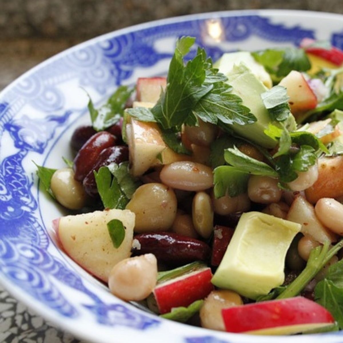 Bowl of bean salad with chickpeas, apple, and avocado.