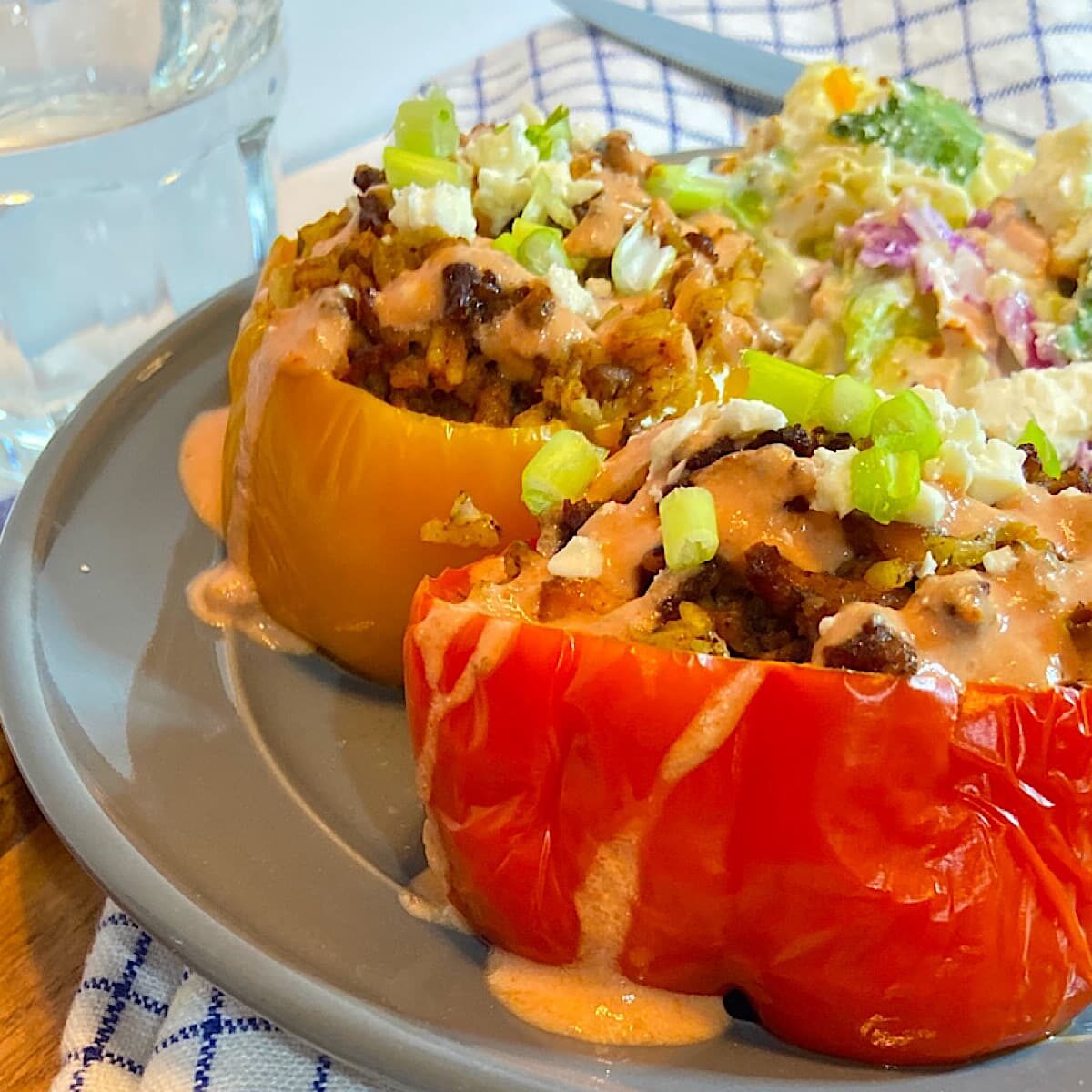 stuffed peppers on plate drizzled with yogurt sauce