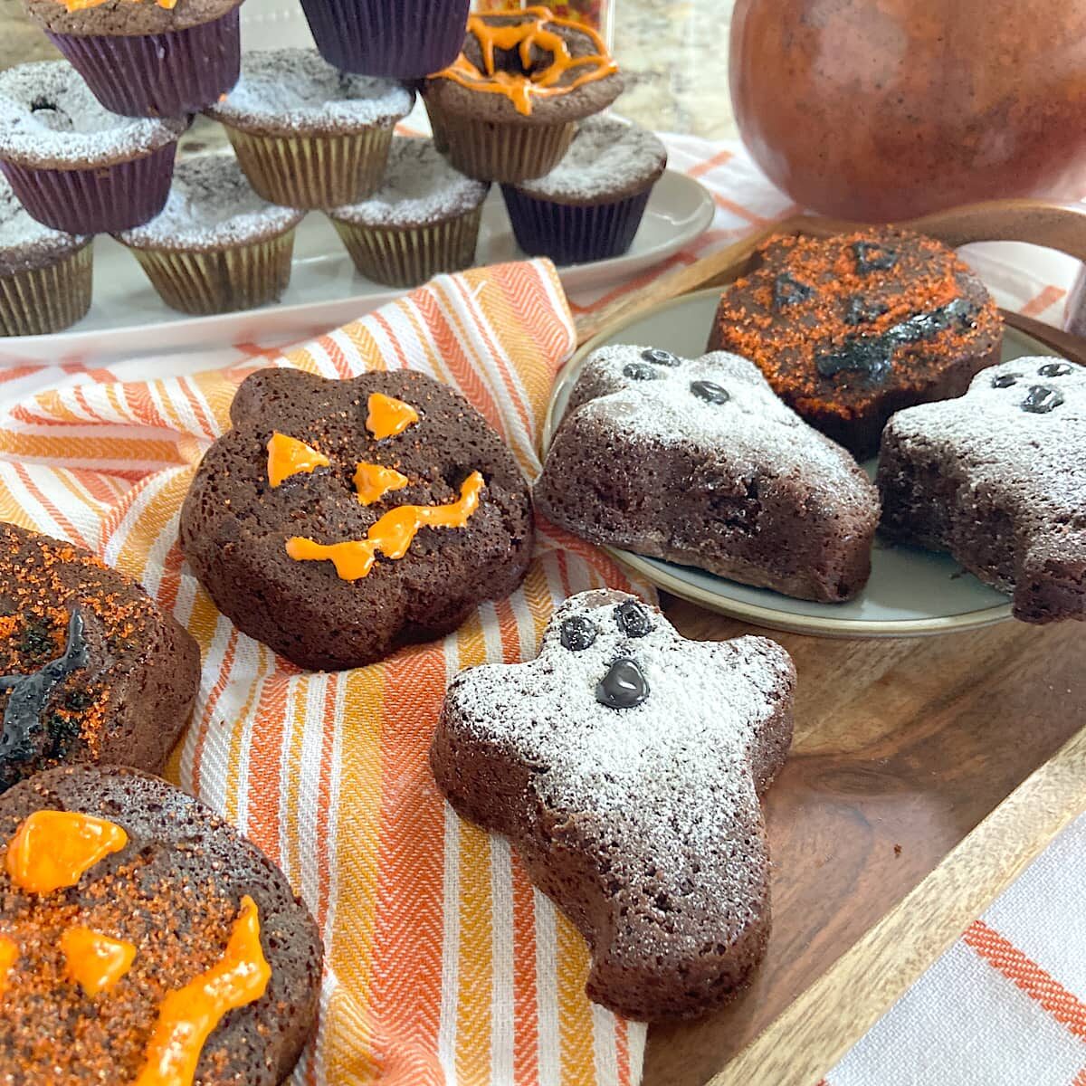 Halloween pumpkins, ghosts, and cupcakes on a tray.