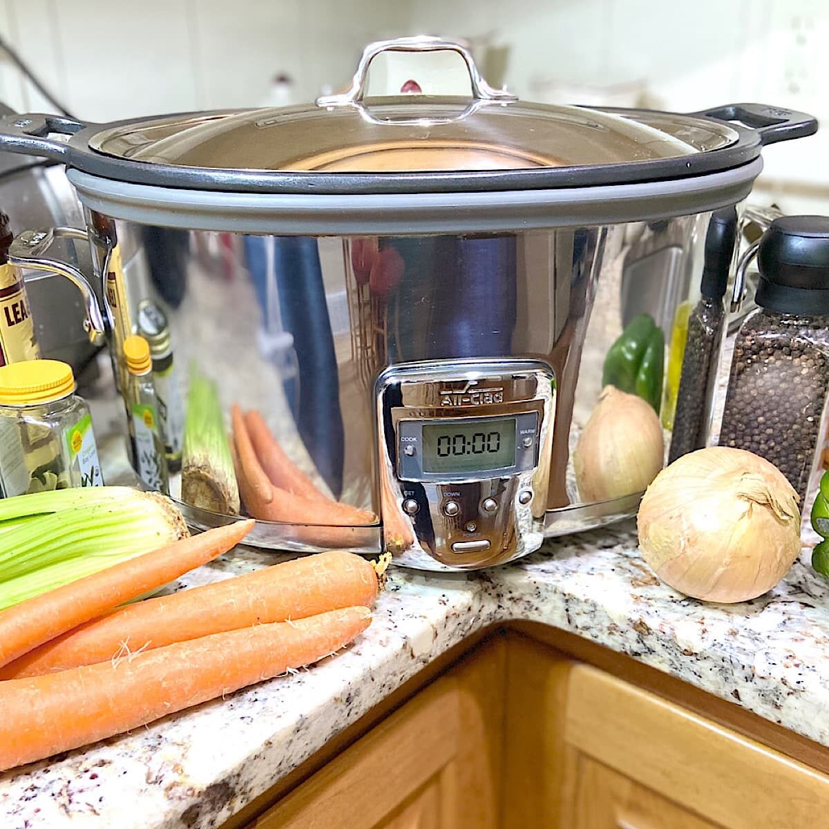 picture of a slow cooker with vegetables and spices.