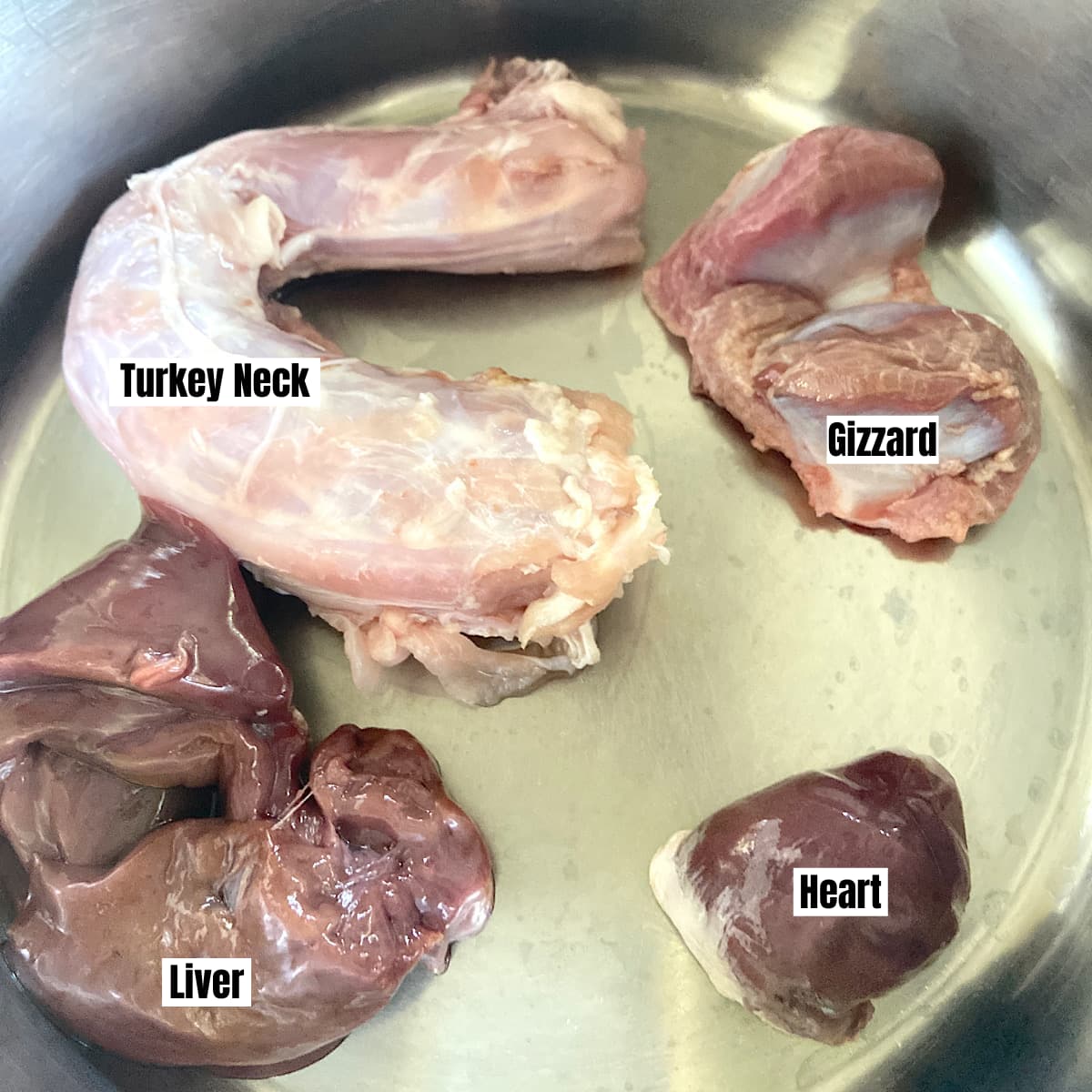 turkey giblets including neck, gizzard, heart and liver in a pan