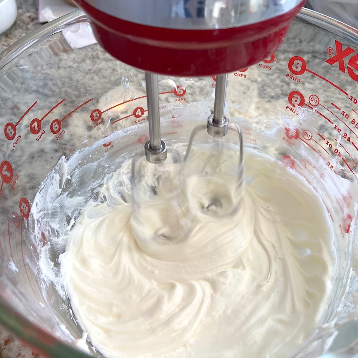 cream cheese mixture in bowl being mixed with hand mixer