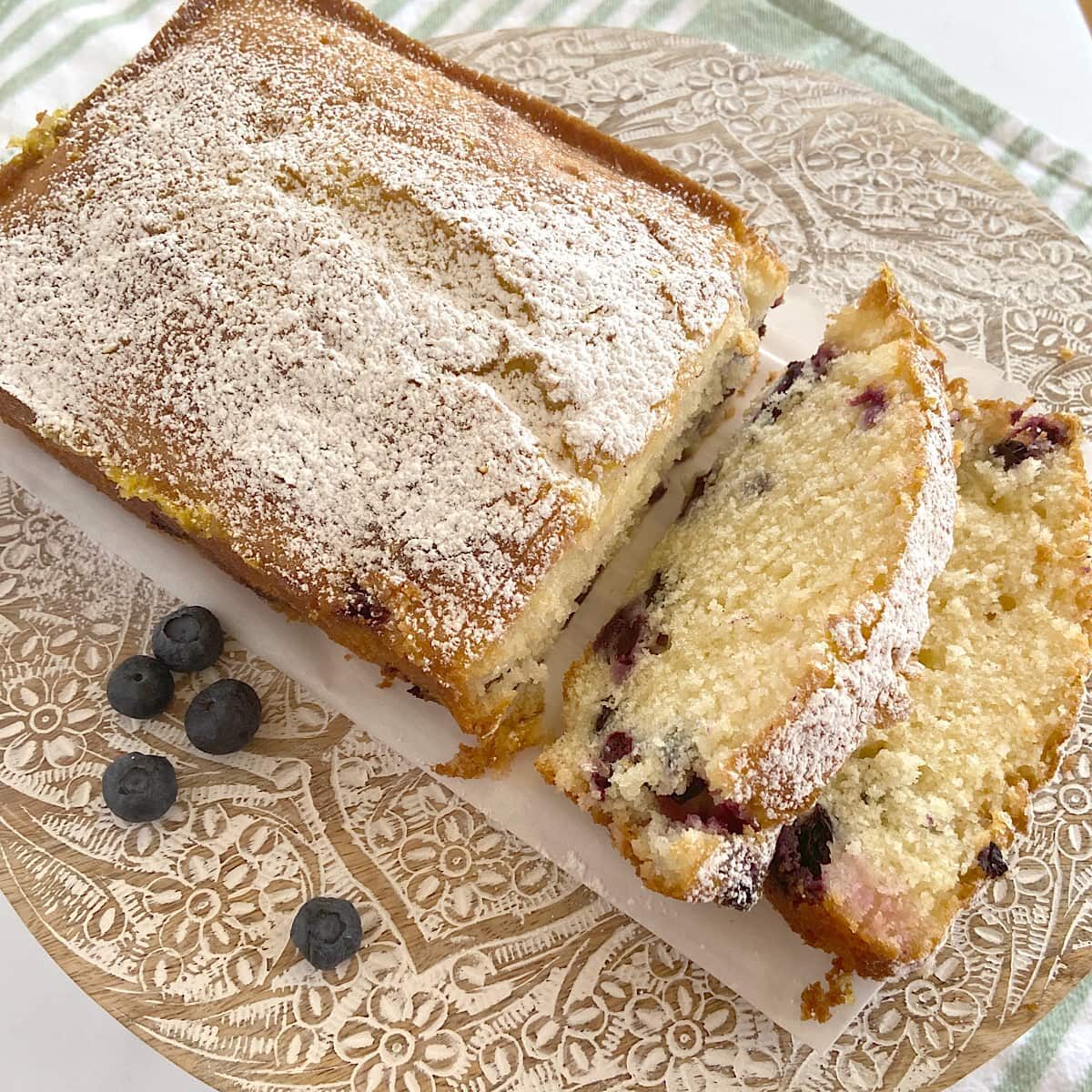 sliced lemon blueberry bread with a dusting of powdered sugar