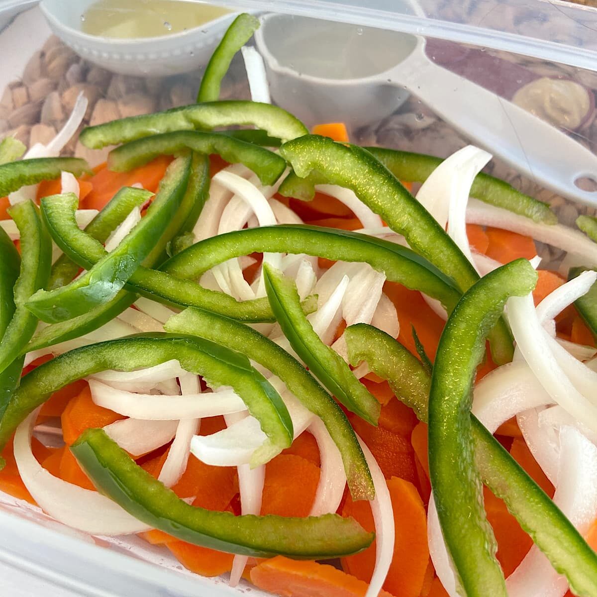 sliced green pepper, onion, and carrots in a container