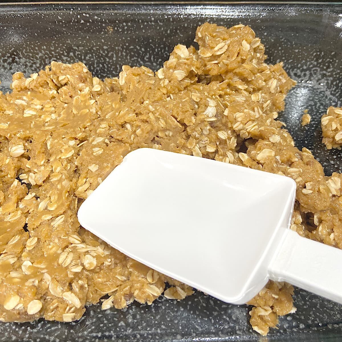 picture of pressing peanut butter oat mixture into baking dish.