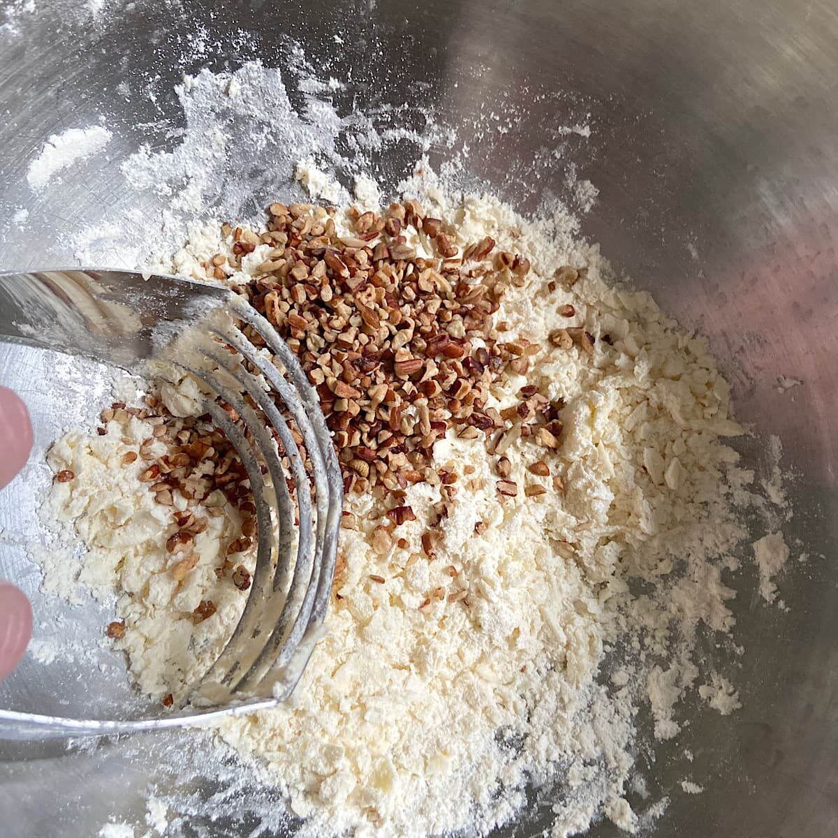 picture of adding nuts to shortbread crust mixture. 