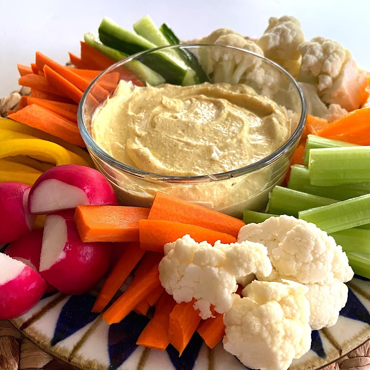 A tray of curry dip with chopped vegetables. 