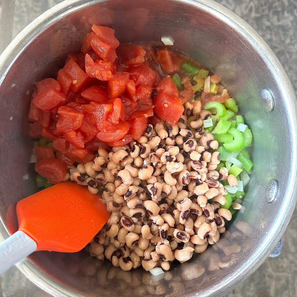 picture of drained black eyed peas, tomatoes mixed with celery, green pepper, and onion.