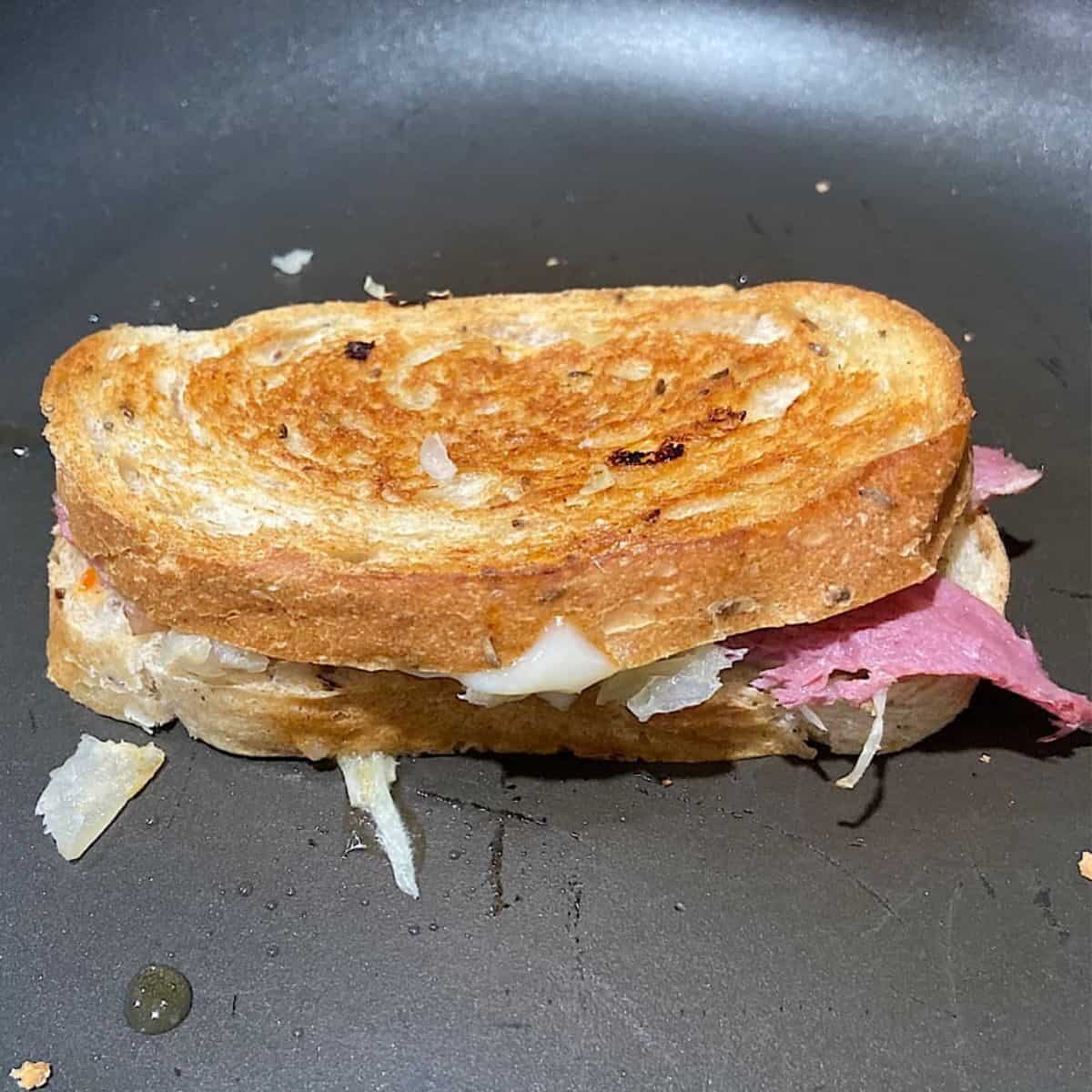 picture of a reuben sandwch in a frying pan.