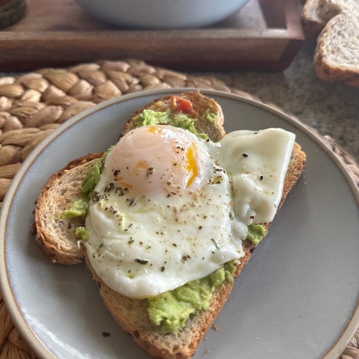 picture of an over-easy egg on whole grain bread and smashed avocado spread.