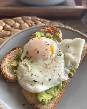 picture of an over-easy egg on whole grain bread and smashed avocado spread.