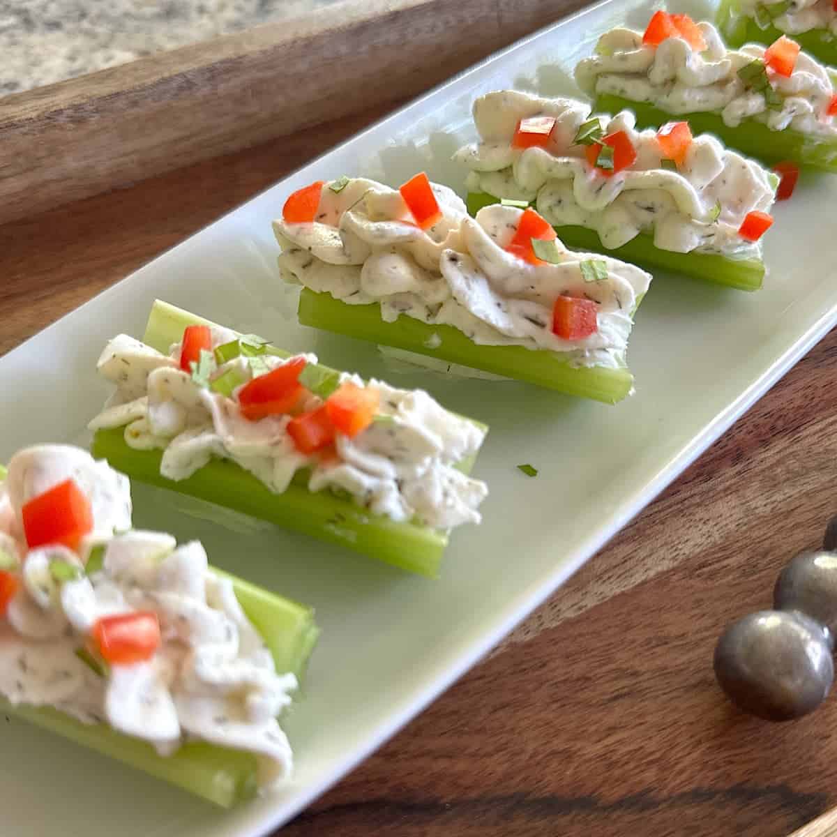 Tray of celery logs filled with dill cream cheese spread.